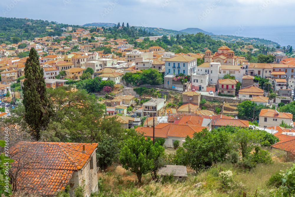 Red roofs of historical Old Town with church. Cityscape of Greece on summer sunny day. Red rooftops of city background. Kymi, Greece. Evia Euboea island, Greece. Traveling location venue, location
