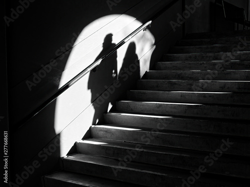 black silhouette of a man and a woman walking on the stairs