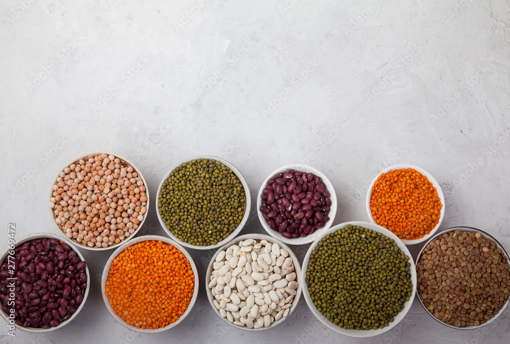 Red and white beans, green and red lentils, sunflower and pumpkin in cups on a white background. superfood Red and white beans, green and red lentils, sunflower and pumpkin in cups on a white background. superfood