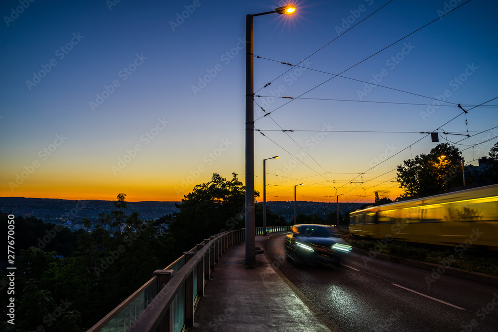 Germany, Traffic of cars and tram of city stuttgart after sunset in summer from above in magical twilight atmosphere