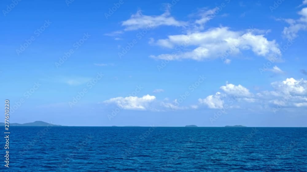 Static shot of an infinity pool with the ocean behind it and blue skies filled with white clouds Static shot of an infinity pool with the ocean behind it and blue skies filled with white clouds