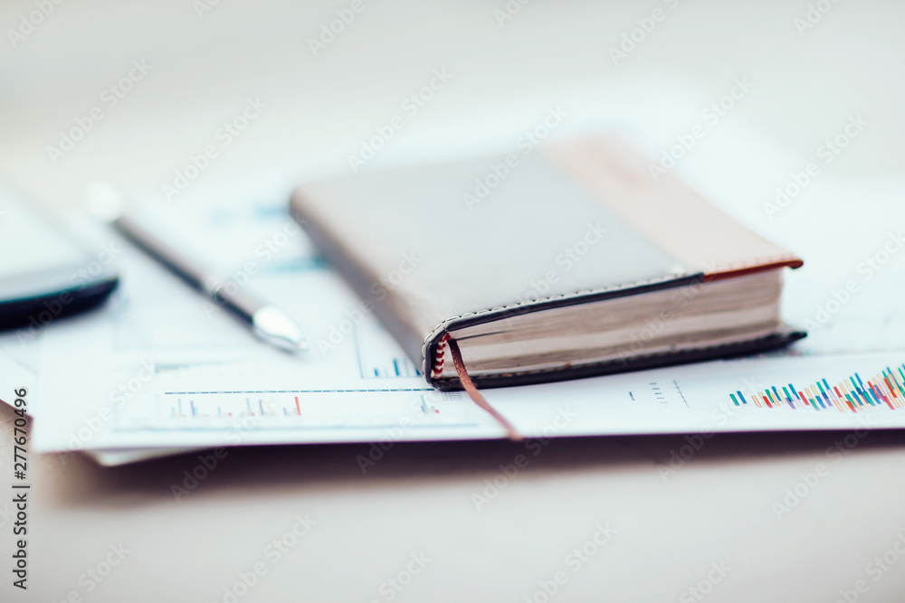notebook and financial chart on the office Desk notebook and financial chart on the office Desk