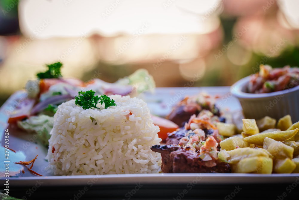 steak served in a restaurant dish with frites and rice