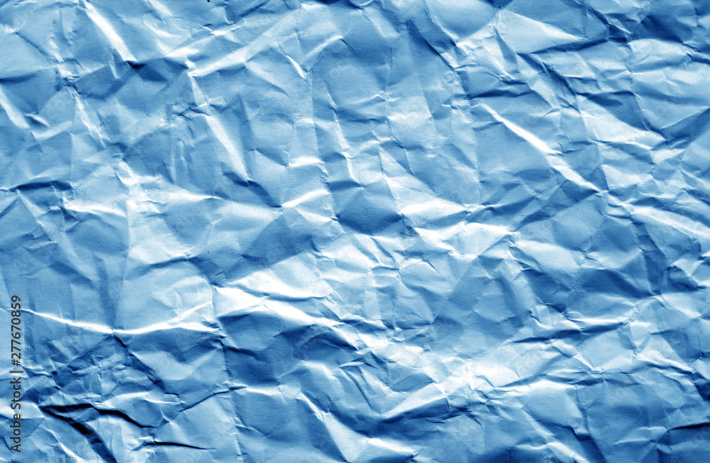 Crumpled sheet of paper with blur effect in navy blue color.