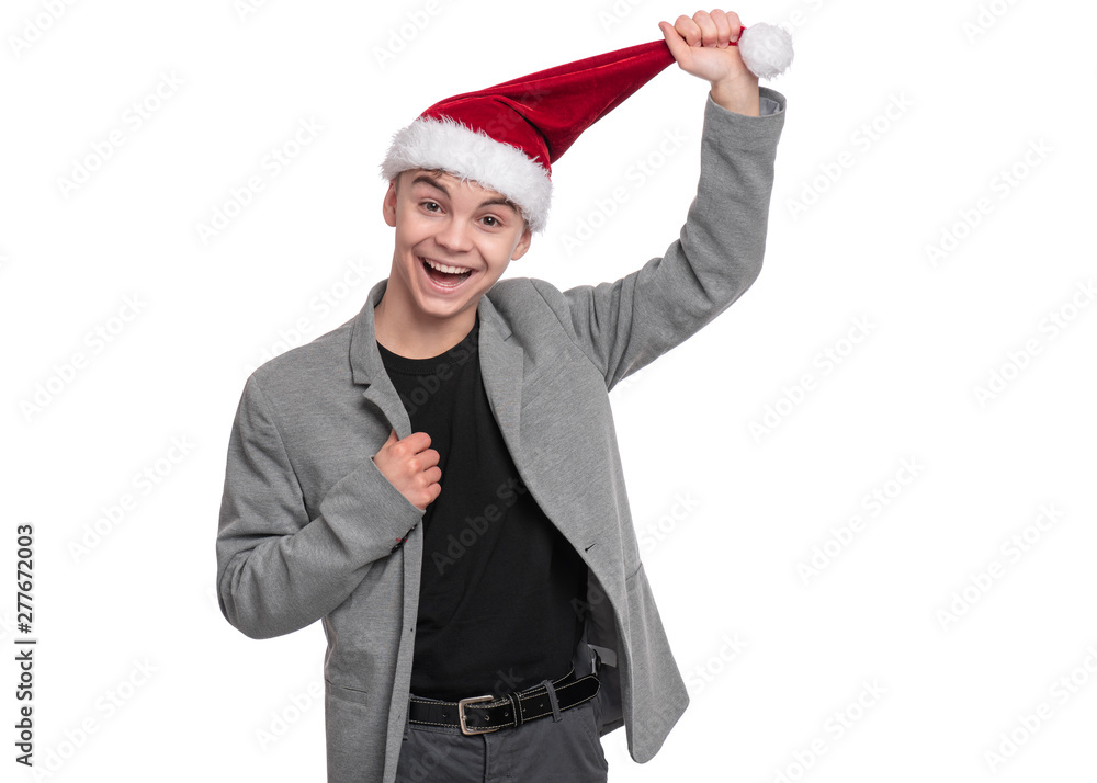 Portrait of teen boy with Christmas hat. Teenager wearing grey suit, smiling and looking at camera. Holiday concept - happy cute child isolated on white background. Portrait of teen boy with Christmas hat. Teenager wearing grey suit, smiling and looking at camera. Holiday concept - happy cute child isolated on white background.