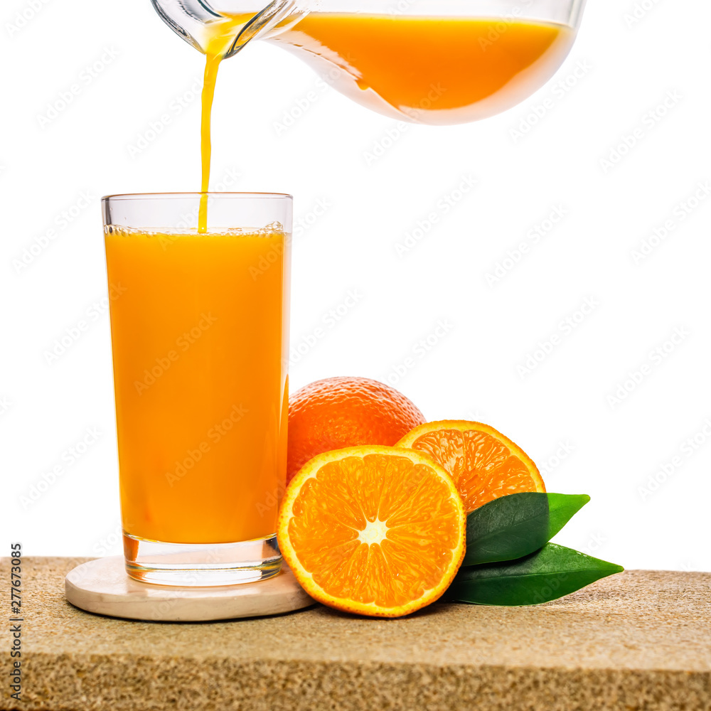 pouring orange juice in glass with fruits on stone isolated on white background, concept of healthy lifestyle pouring orange juice in glass with fruits on stone isolated on white background, concept of healthy lifestyle