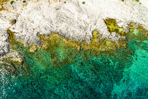 Aerial overhead shot of rocky seashore with crystal clear blue water on the island of Dugi Otok in Croatia