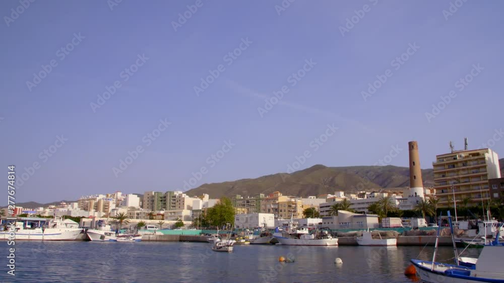 Fishing harbor of southern Spain with boats docked with the city in the background Fishing harbor of southern Spain with boats docked with the city in the background