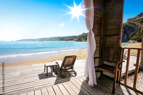 Wooden terrace on beach and sunbed 