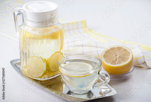   Lemon water in a glass jug and in a glass cup