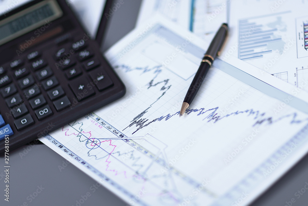 close up.pen, financial chart and calculator on the businessman's Desk close up.pen, financial chart and calculator on the businessman's Desk