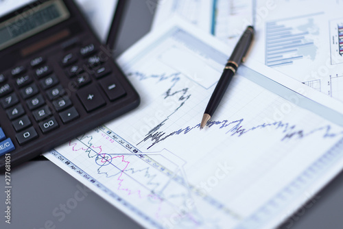 close up.pen, financial chart and calculator on the businessman's Desk
