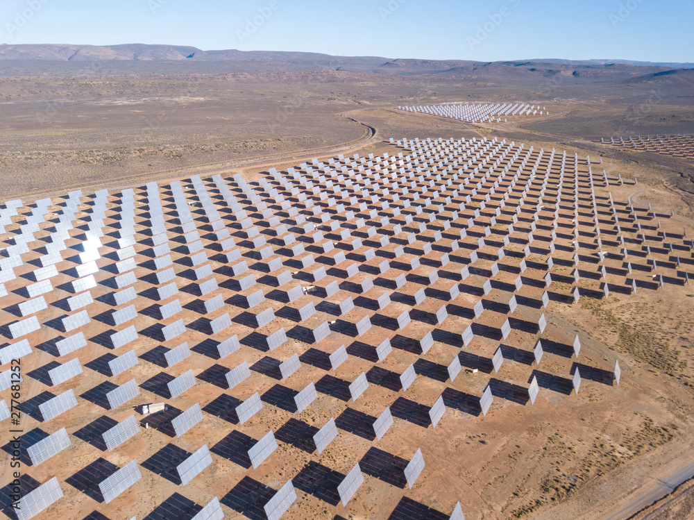Fototapeta premium Aerial over solar panels in a dry landscape
