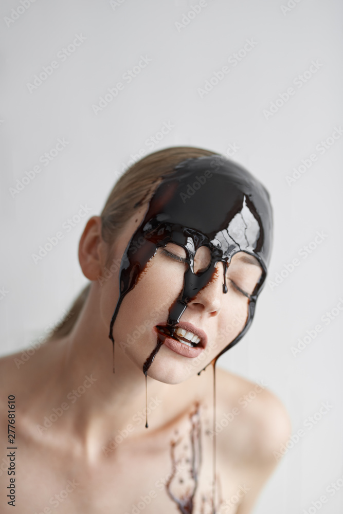 Emotion Concept. Woman standing isolated on white closed eyes joyful head in chocolate sauce close-up Emotion Concept. Woman standing isolated on white closed eyes joyful head in chocolate sauce close-up