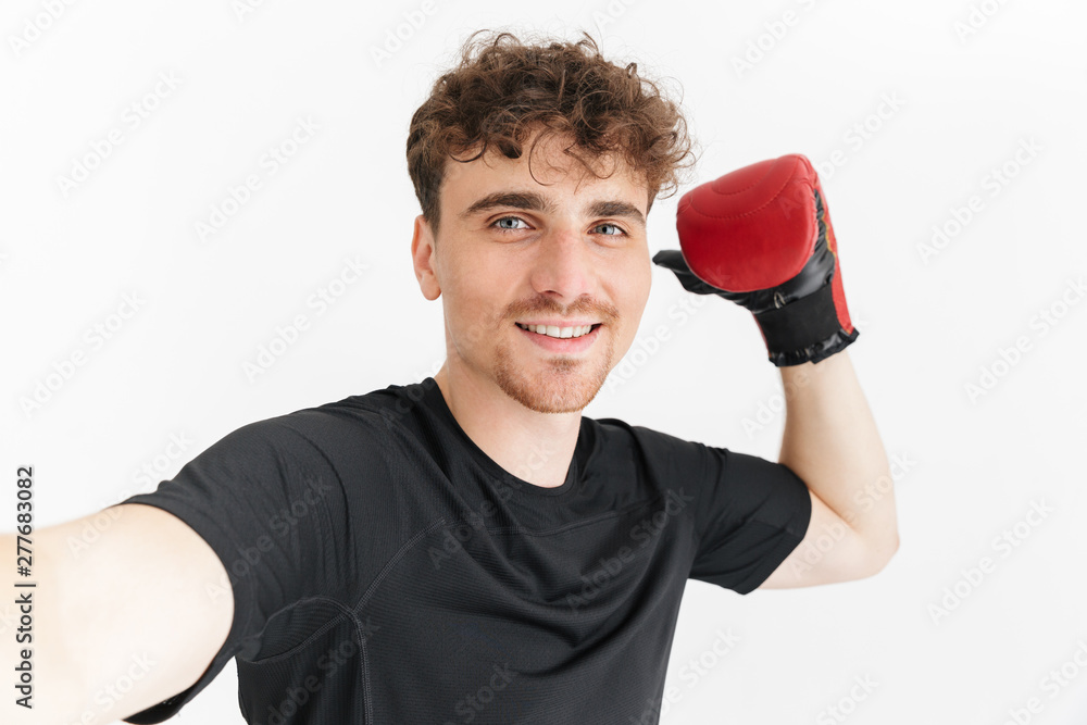 Photo closeup of young sporty man in t-shirt smiling and taking selfie photo in boxing glove Photo closeup of young sporty man in t-shirt smiling and taking selfie photo in boxing glove