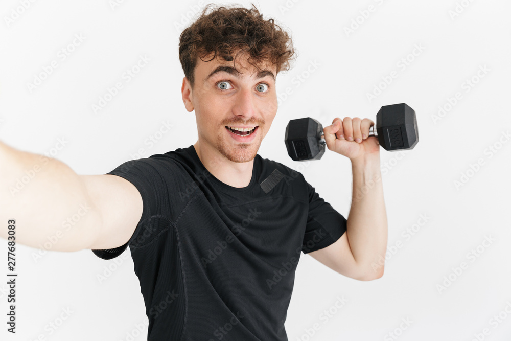 Photo closeup of handsome sporty man in t-shirt looking at camera and taking selfie photo while holding dumbbell Photo closeup of handsome sporty man in t-shirt looking at camera and taking selfie photo while holding dumbbell