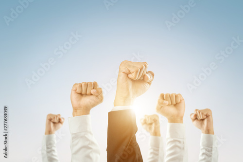 Businessmen raised their hands to win the celebration of the organization.The concept of business is geared towards success,sunlight effect. photo