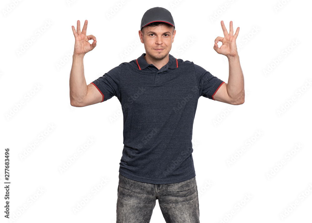 Happy Delivery man in gray t-shirt and cap. Studio portrait of caucasian handsome guy making Ok gesture and looking at camera. Courier isolated on white background. Happy Delivery man in gray t-shirt and cap. Studio portrait of caucasian handsome guy making Ok gesture and looking at camera. Courier isolated on white background.