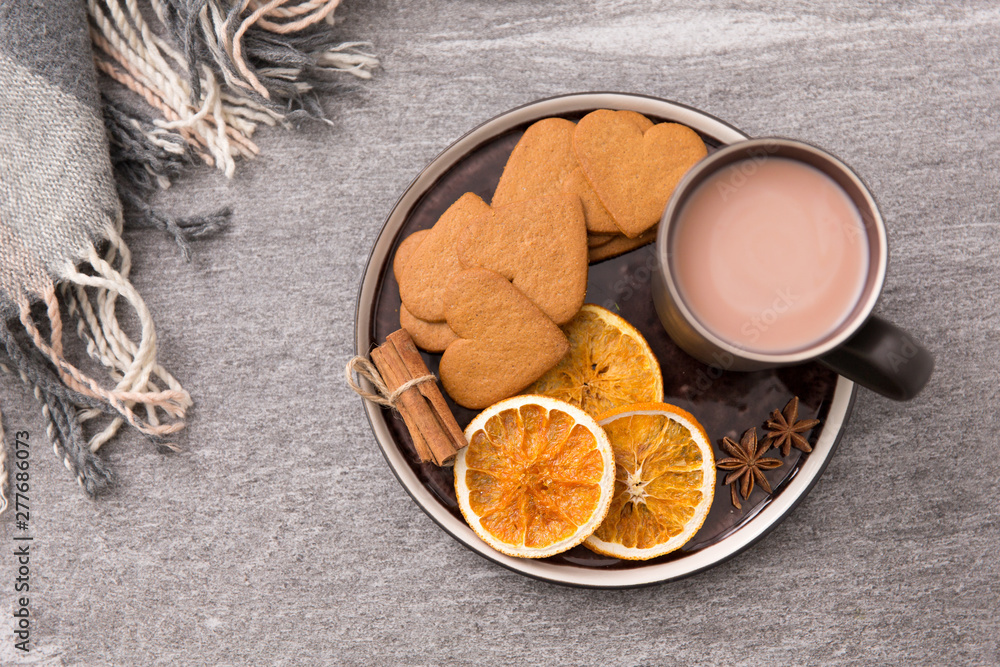 drinks and season concept - cup of hot chocolate with dried orange, heart shaped gingerbread cookies, cinnamon and anise on plate or tray and warm blanket drinks and season concept - cup of hot chocolate with dried orange, heart shaped gingerbread cookies, cinnamon and anise on plate or tray and warm blanket