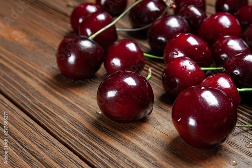 Ripe juicy cherries on a wooden background. Wet fresh sweet cherries with water drops.