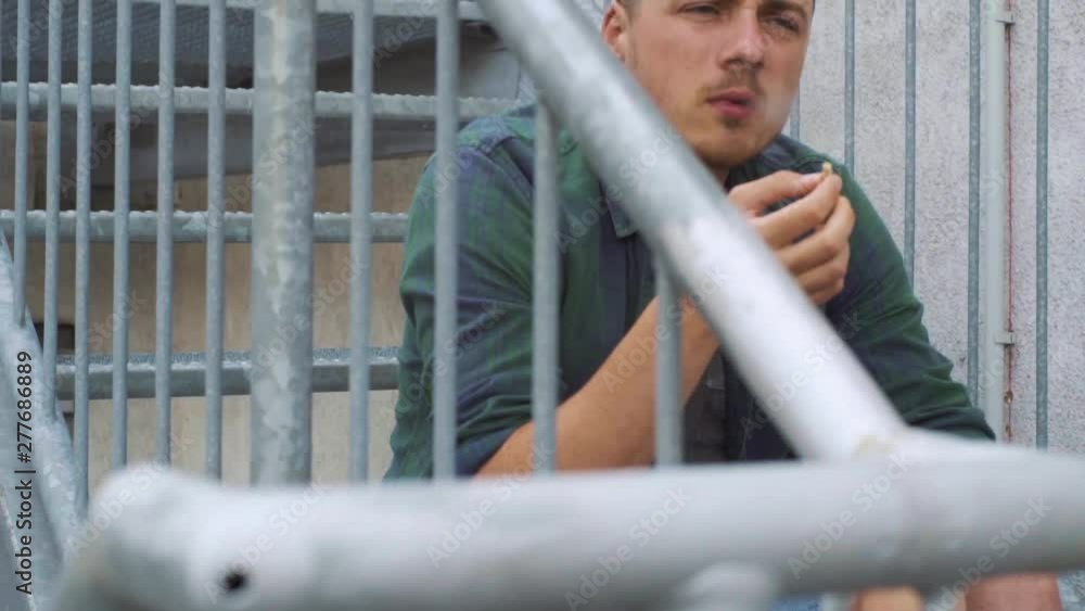 Guy smoking a cigarette on the fire escape Guy smoking a cigarette on the fire escape