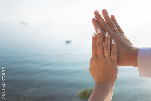 Wedding couple holding hands on sea sunset background