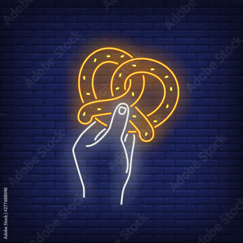 Hand holding pretzel neon sign. Oktoberfest, appetizer, food design. Night bright neon sign, colorful billboard, light banner. Vector illustration in neon style.