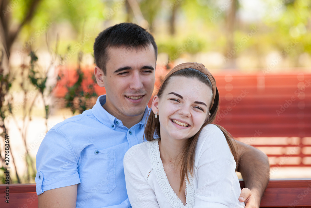 Young couple sitting on bench in park. Young couple sitting on bench in park.