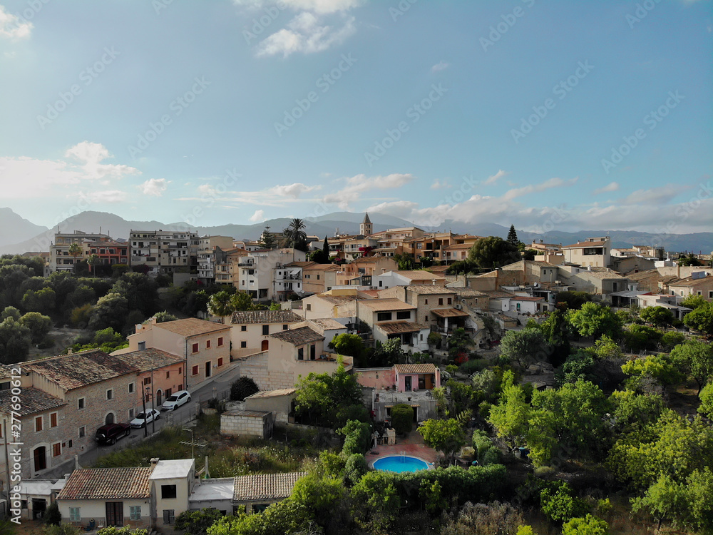 Aerial photo drone point of view image Campanet town hillside residential old ancient houses building exterior situated in the northeast of Majorca Island, Spain