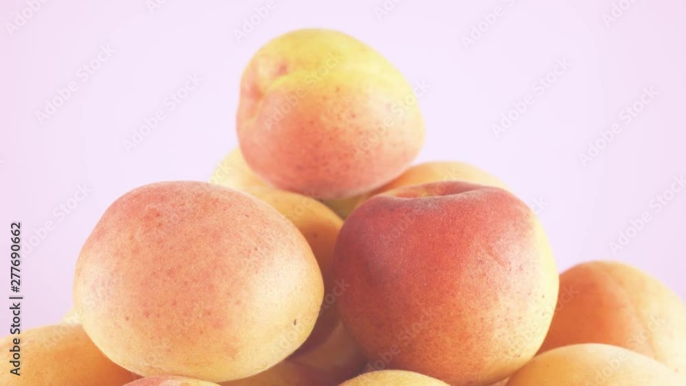 Peaches and apricots of bright yellow and red colors. Healthy and healthy food from fruits. Light isolated cream background. Peaches and apricots of bright yellow and red colors. Healthy and healthy food from fruits. Light isolated cream background.