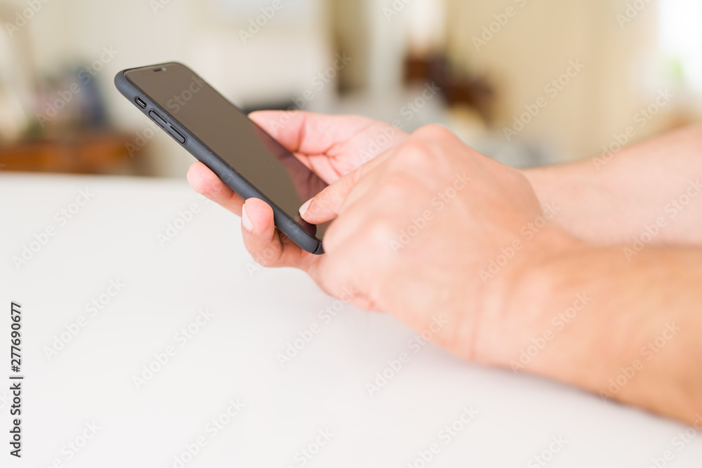 Close up of middle age man hands using smartphone at home