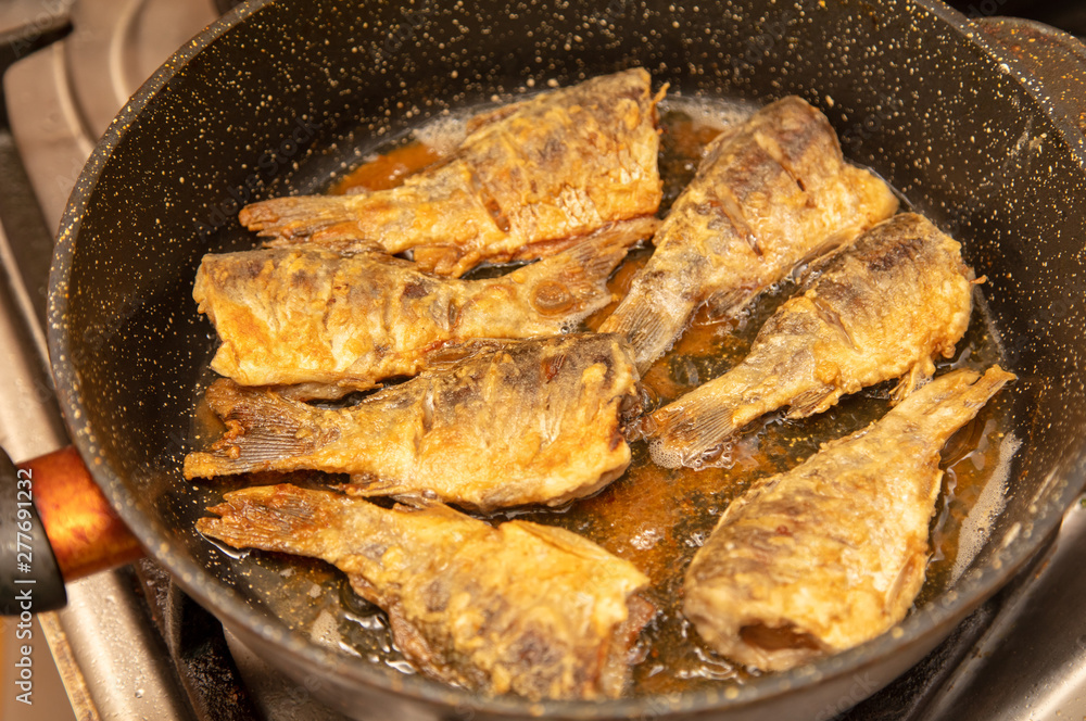 Fried fish in a pan in the kitchen Fried fish in a pan in the kitchen