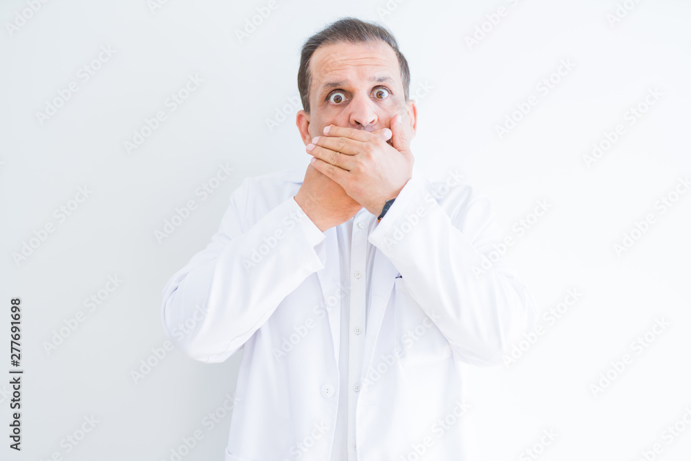 Middle age doctor man wearing medical coat over white background shocked covering mouth with hands for mistake. Secret concept. Middle age doctor man wearing medical coat over white background shocked covering mouth with hands for mistake. Secret concept.