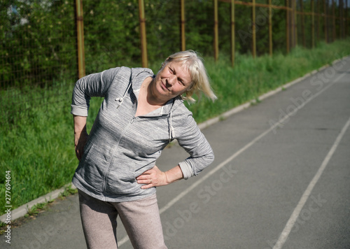Aged woman doing exercises in public stadium. © Vladimir Arndt