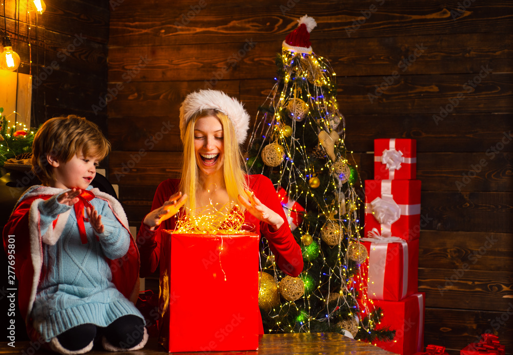 Obraz premium Happy family. Mother and little child boy son friendly family having fun. Cozy evening at home. Family having fun at home christmas tree. Family holiday. Mom and kid play together christmas eve