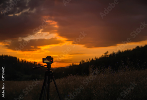 Mobile phone on tripod record time lapse of clouse sunset. Czech landscape