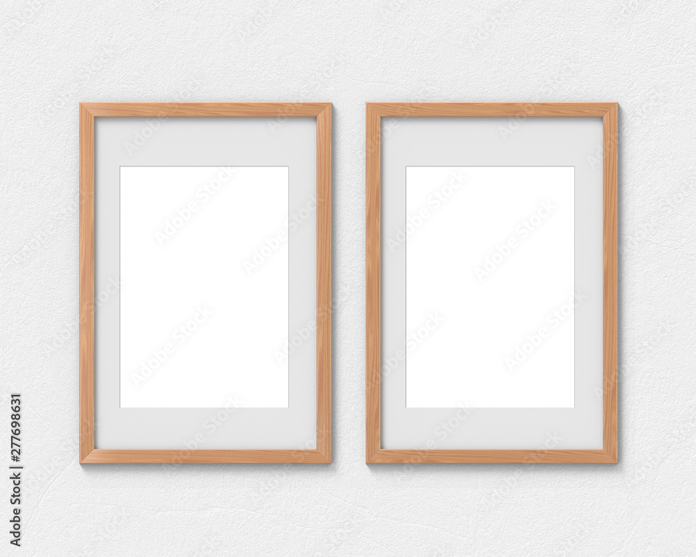 Set of 2 vertical wooden frames mockup with a border hanging on the wall. Empty base for picture or text. 3D rendering.