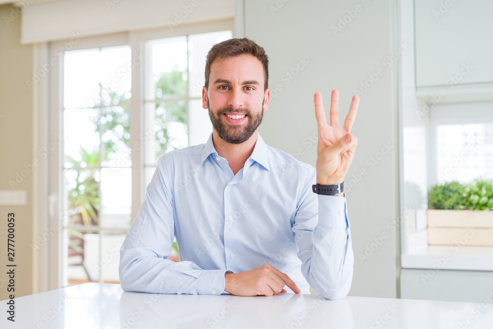 Handsome business man showing and pointing up with fingers number three while smiling confident and happy.