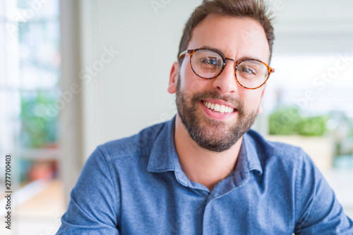 Fototapeta Naklejka Na Ścianę i Meble -  Handsome man wearing glasses and smiling relaxed at camera