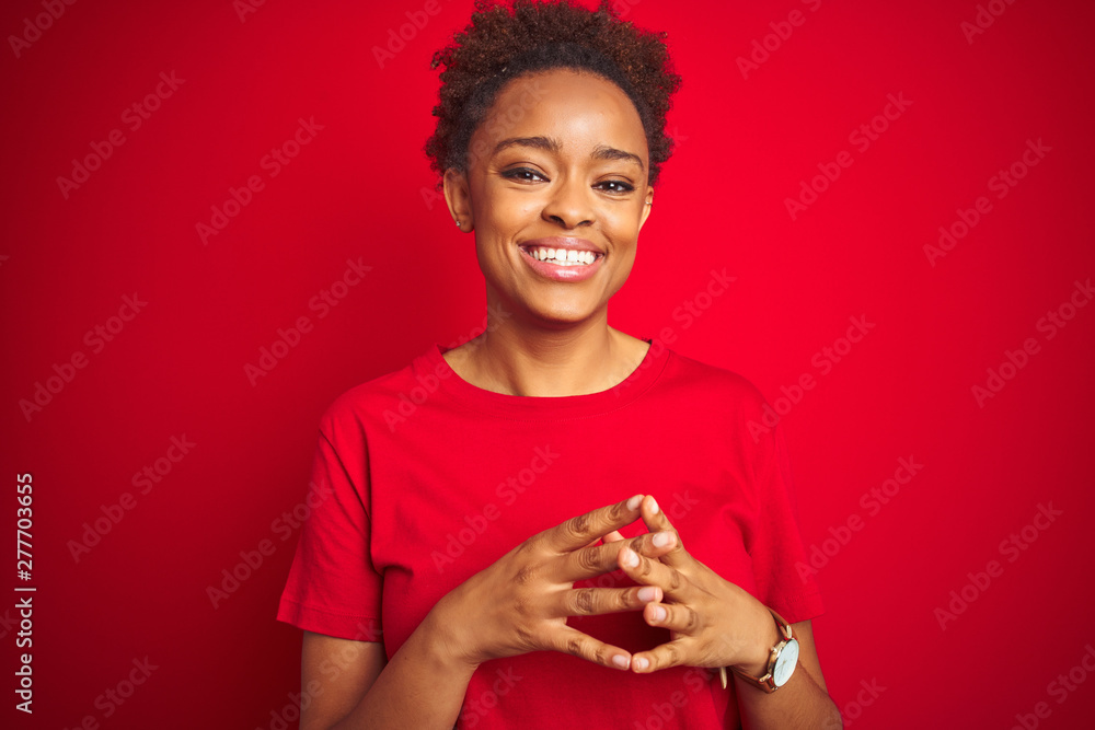 Young beautiful african american woman with afro hair over isolated red background Hands together and fingers crossed smiling relaxed and cheerful. Success and optimistic Young beautiful african american woman with afro hair over isolated red background Hands together and fingers crossed smiling relaxed and cheerful. Success and optimistic