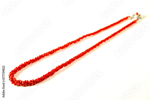 3連の赤珊瑚のネックレスと白バック