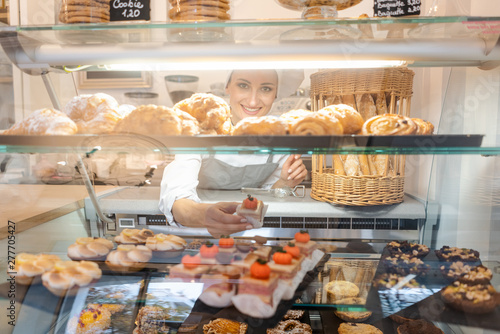 Confectioner shot through glass display in her shop