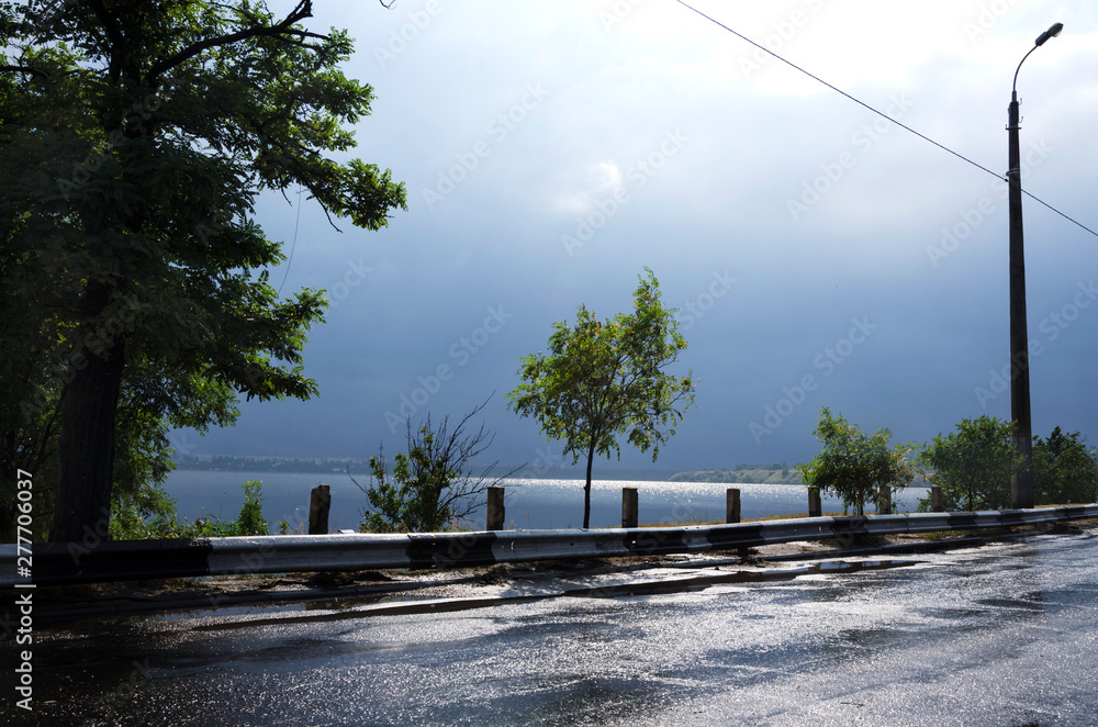 Road after rain near the river. Severe weather befor storm