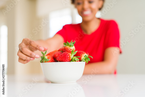 Close up of young woman eating fresh strawberries