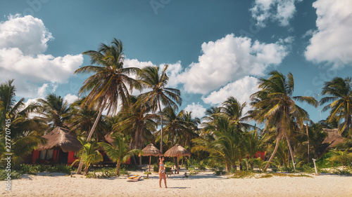Palm trees and the girl on the white beach in Tulum caribbean, Mexico photo