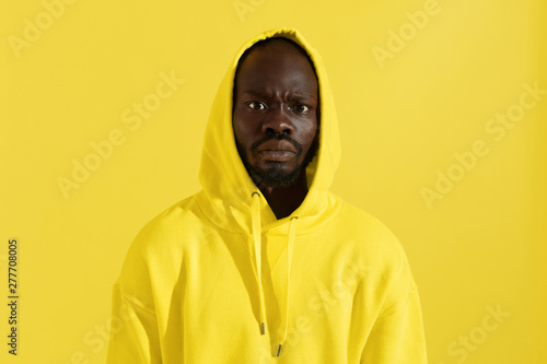 Black man in yellow hoodie with shocked face, colorful portrait © puhhha