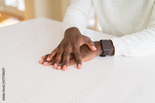 Close up of hands of african man over table