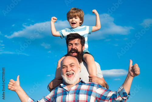 Fathers day concept. Happy three generations of men have fun and smiling on blue sky background. Happy family.