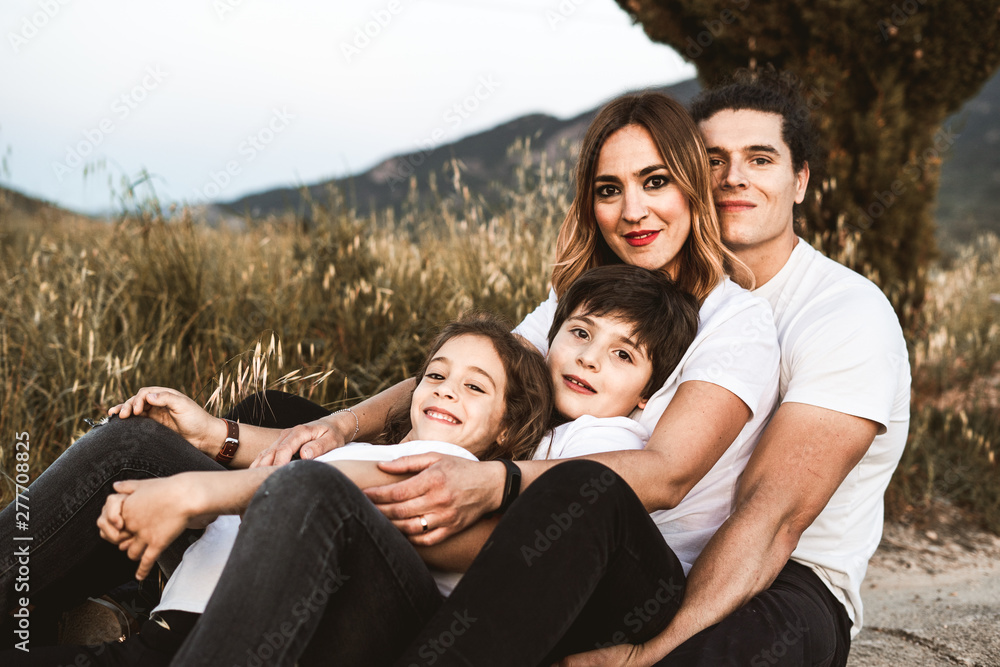 Fototapeta premium Portrait of a happy and funny young family outdoors
