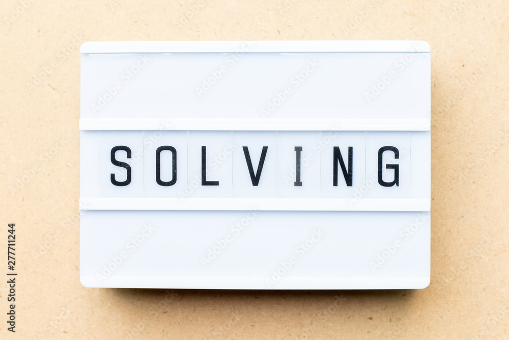 White lightbox with word solving on wood background White lightbox with word solving on wood background